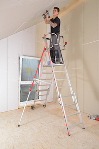 plaquiste fixant des plaques placo au plafond . Il est grimpé sur une une plate forme individuelle roulante, de 8 marches, qui lui permet de travailler avec ses 2 mains libres. Son bas de corps est sécurisé par sur la plateforme avec garde-corps évitant ainsi les déséquilibres et les chutes. Le stabilisateur évite que l’échelle se renverse.